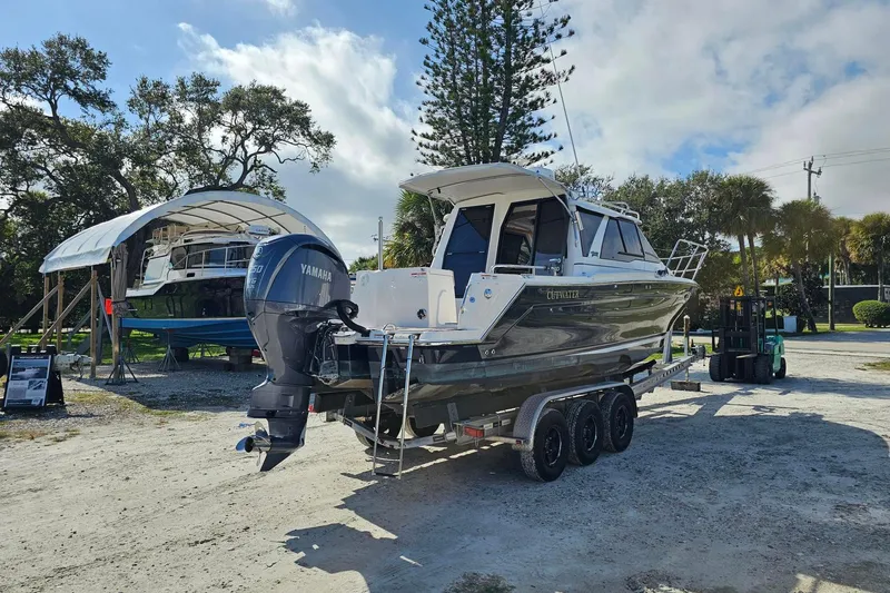 Slide: The Image of 2024 Cutwater C-248 Coupe boat on trailer with Yamaha outboard motor, parked outdoors. - 6