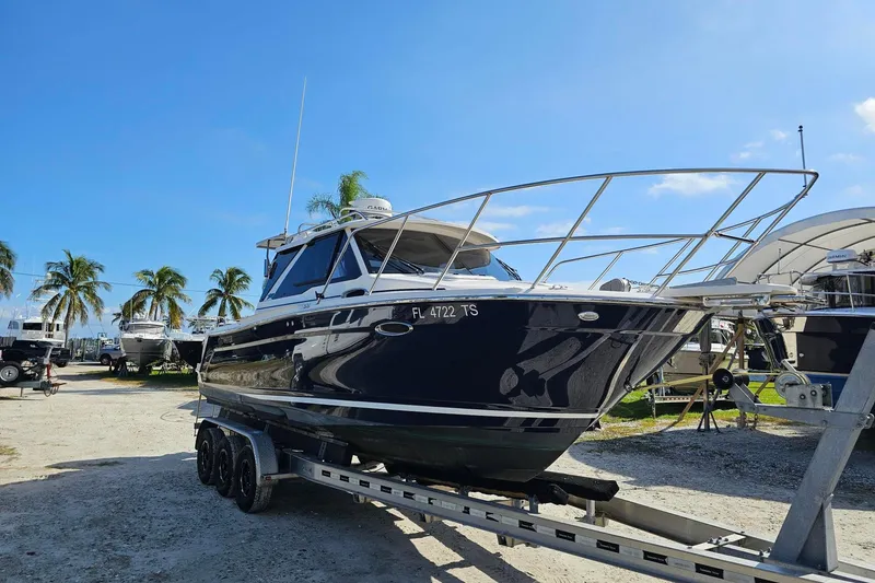 Slide: The Image of 2024 Cutwater C-248 Coupe on trailer, blue sky, palm trees in background. - 7
