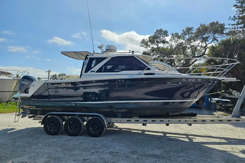 Slide: The Image of 2024 Cutwater C-248 Coupe boat on trailer, parked outdoors under clear sky. - 8