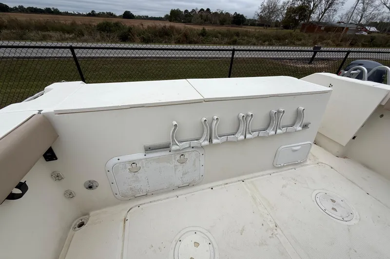 Slide: The Image of 1997 Pursuit 2800 Offshore boat deck with rod holders and storage compartments. - 10