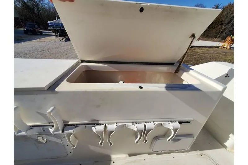 Slide: The Image of Open storage compartment on a 1997 Pursuit 2800 Offshore boat, featuring rod holders. - 11