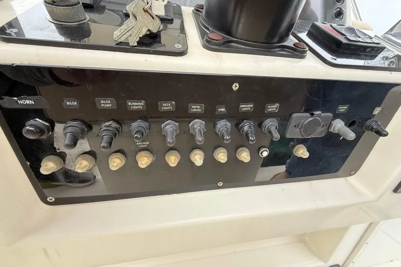Slide: The Image of Control panel of a 1997 Pursuit 2800 Offshore boat with labeled switches and keys. - 22