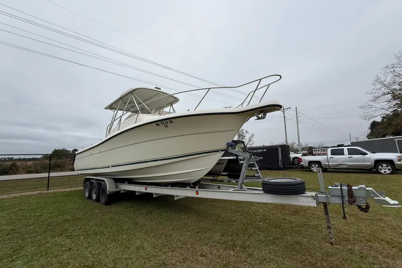 Slide: The Image of 1997 Pursuit 2800 Offshore boat on trailer, parked on grass. - 3