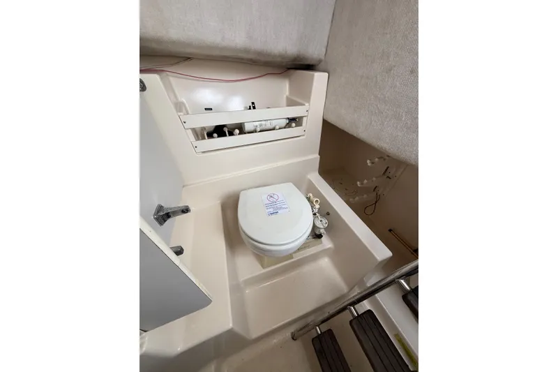 Slide: The Image of 1997 Pursuit 2800 Offshore boat interior with compact marine toilet and storage. - 31