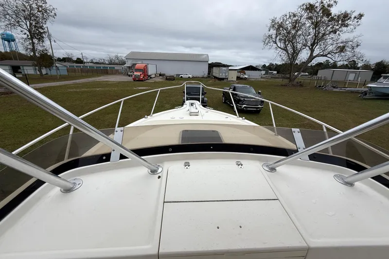 Slide: The Image of 1997 Pursuit 2800 Offshore boat on land, surrounded by vehicles and buildings. - 34