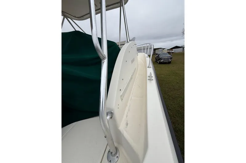 Slide: The Image of 1997 Pursuit 2800 Offshore boat with railing, parked on grass near a vehicle. - 35