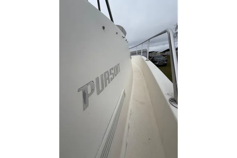 Slide: The Image of 1997 Pursuit 2800 Offshore boat side view with railing and logo. - 36