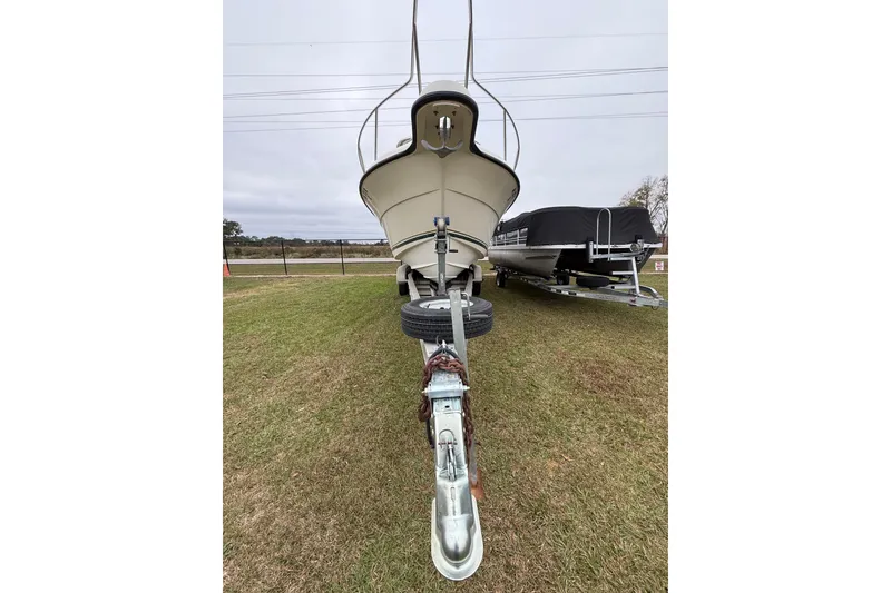 Slide: The Image of 1997 Pursuit 2800 Offshore boat on trailer, parked on grass. - 4