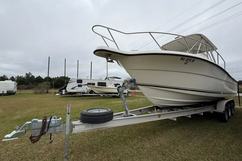 Slide: The Image of 1997 Pursuit 2800 Offshore boat on trailer, parked on grass with RVs in background. - 5