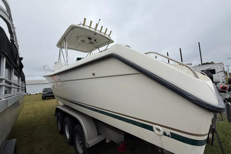 Slide: The Image of 1997 Pursuit 2800 Offshore boat on trailer, side view, overcast sky. - 6
