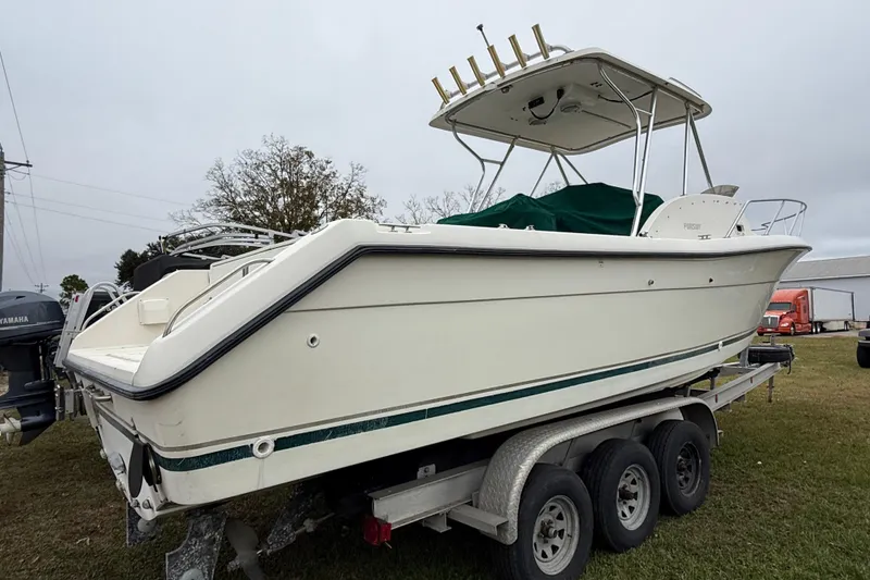 Slide: The Image of 1997 Pursuit 2800 Offshore boat on trailer, side view, overcast sky. - 7
