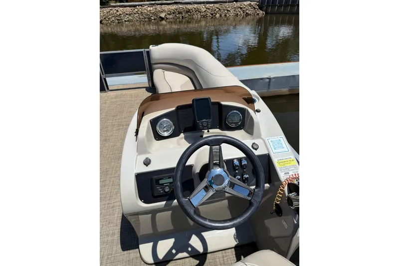 Slide: The Image of 2023 Cypress Cay Seabreeze 232 boat dashboard with steering wheel and controls. - 4