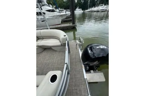 Slide: The Image of 2023 Cypress Cay Seabreeze 232 pontoon boat docked with outboard motor. - 12