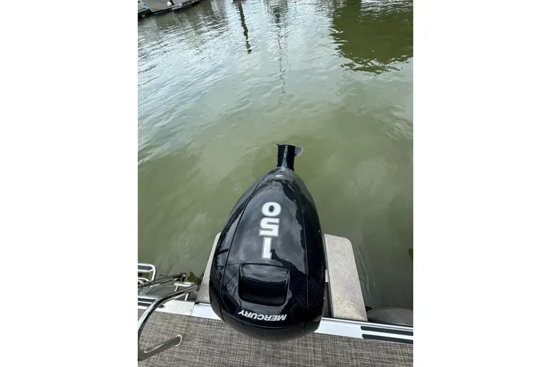 Slide: The Image of Outboard motor on 2023 Cypress Cay Seabreeze 232 pontoon boat, docked on calm water. - 13