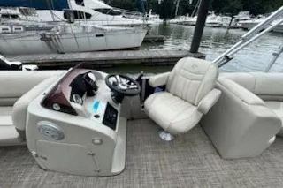 Slide: The Image of 2023 Cypress Cay Seabreeze 232 boat interior with helm and seating at marina. - 4