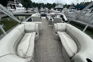 Slide: The Image of 2023 Cypress Cay Seabreeze 232 pontoon boat with spacious seating at a marina. - 5