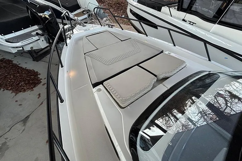 Slide: The Image of 2026 Navan S30 boat with cushioned deck, docked alongside other vessels. - 15