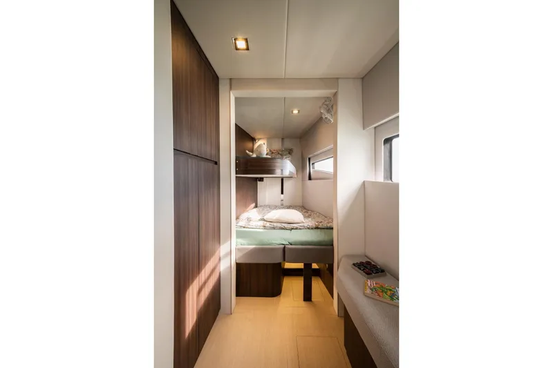 Slide: The Image of Modern Catana OC2 2026 yacht cabin with bunk beds and sleek wooden finishes. - 24