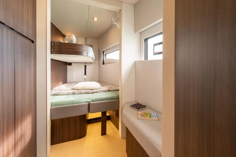 Slide: The Image of Cozy cabin interior of 2026 Catana OC2 with bed, wooden accents, and natural light. - 25