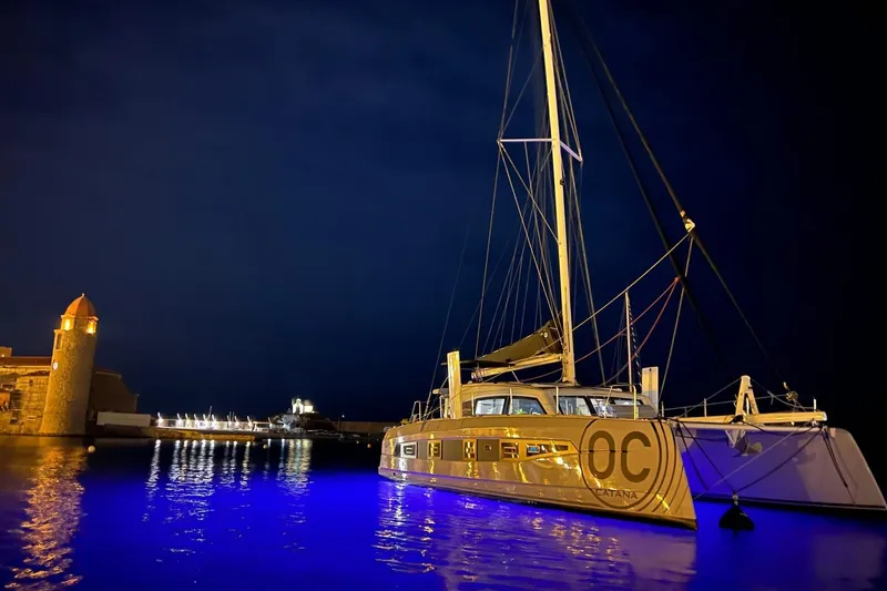 Slide: The Image of 2026 Catana OC2 catamaran illuminated at night in a serene harbor setting. - 3
