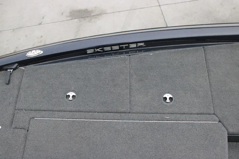 Slide: The Image of 2022 Skeeter ZX225 boat deck with gray carpet and storage compartments. - 24