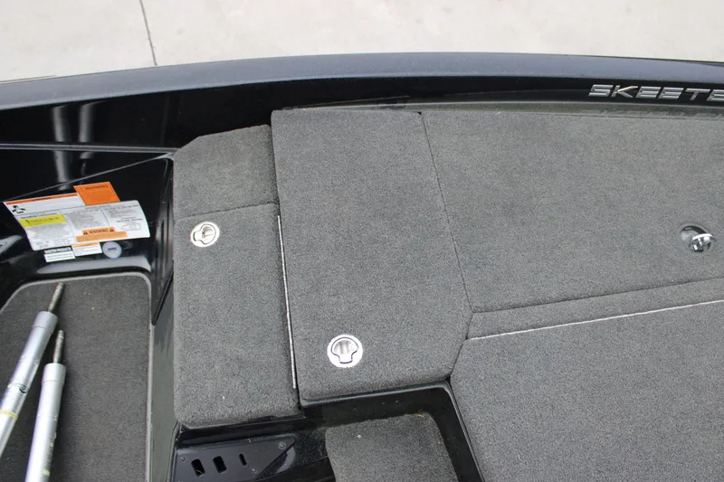 Slide: The Image of 2022 Skeeter ZX225 boat deck with gray carpet and storage compartments. - 25