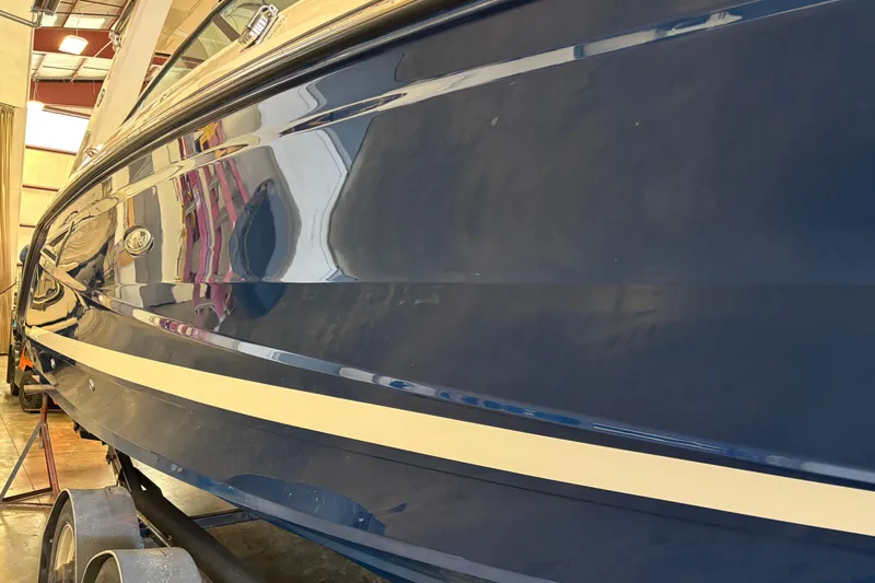 Slide: The Image of 2023 Sea Ray SLX 310 boat in a showroom, showcasing sleek blue hull design. - 4