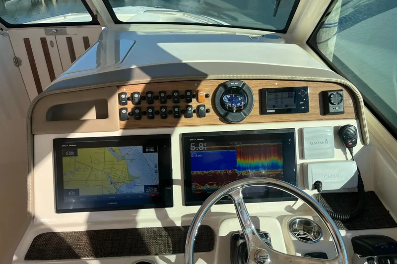 Slide: The Image of 2015 Grady-White Freedom 375 boat dashboard with Garmin navigation displays and controls. - 11