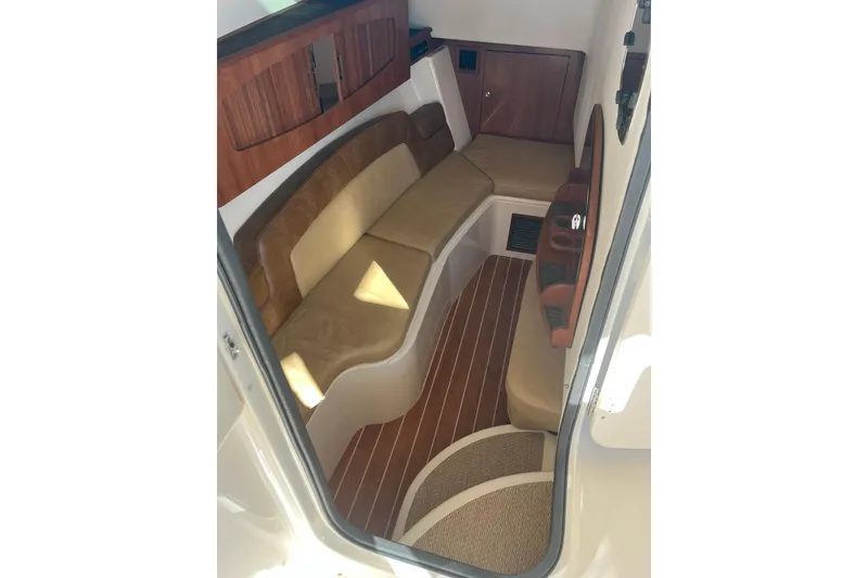 Slide: The Image of 2015 Grady-White Freedom 375 cabin interior with cushioned seating and wood accents. - 13