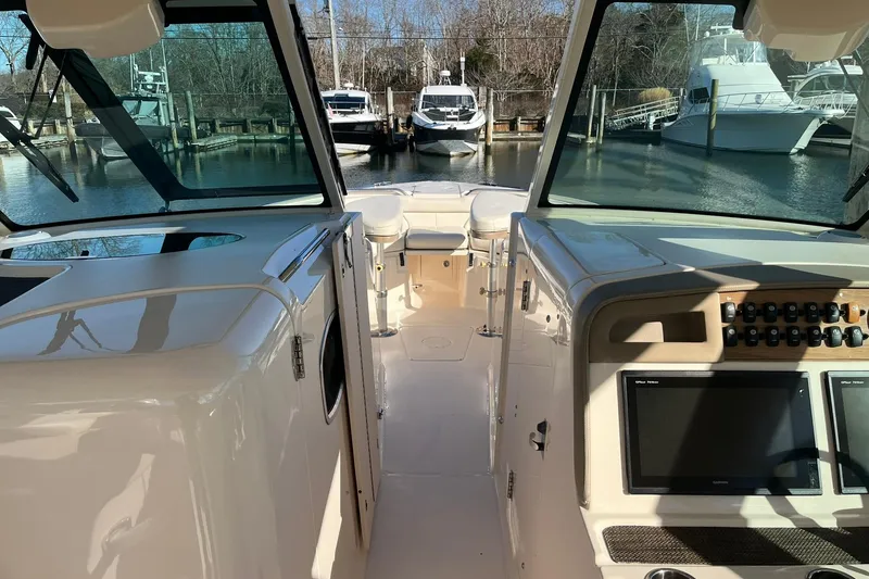 Slide: The Image of 2015 Grady-White Freedom 375 boat interior with dashboard and marina view. - 8