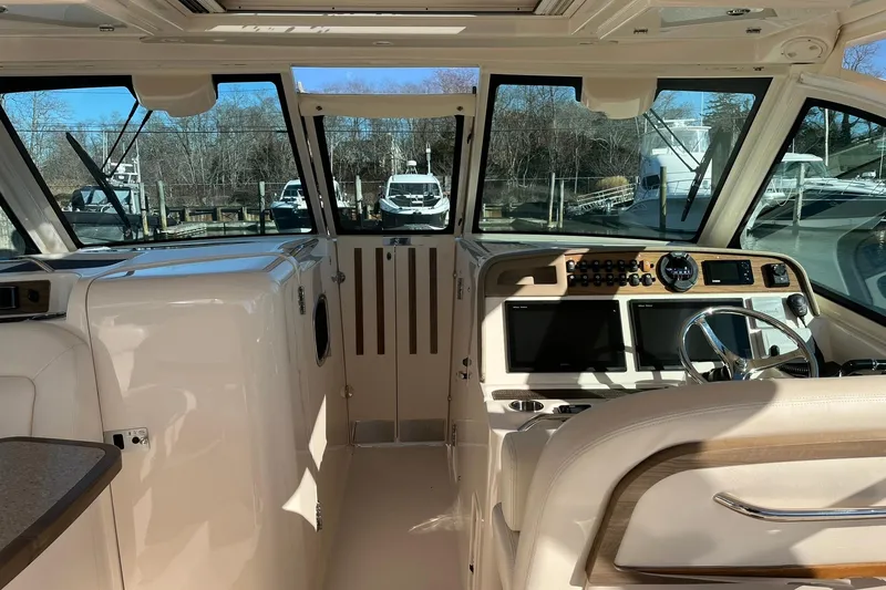 Slide: The Image of 2015 Grady-White Freedom 375 boat interior with helm, steering wheel, and navigation screens. - 9