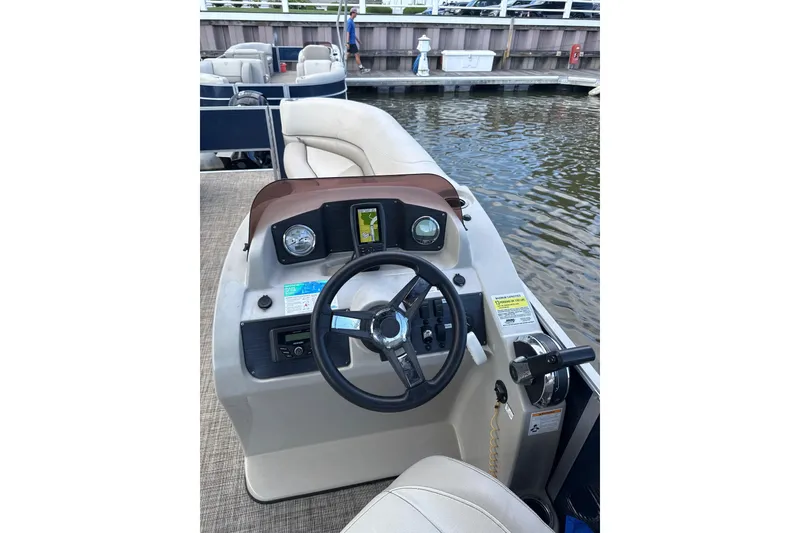 Slide: The Image of 2023 Cypress Cay Seabreeze 232 boat dashboard with steering wheel and controls. - 6