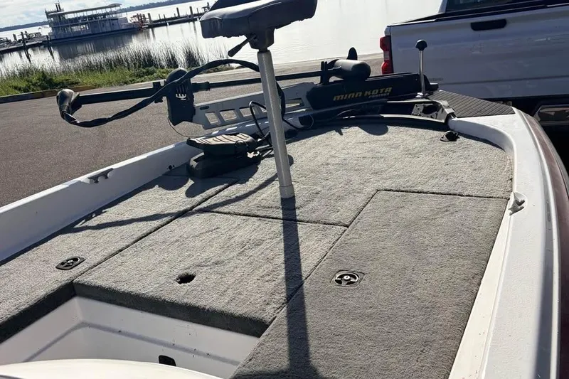 Slide: The Image of 1998 Hydra-Sports 185 boat deck with trolling motor, docked near a waterfront. - 3