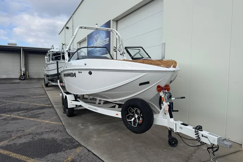 Slide: The Image of 2026 Moomba Mondo boat on trailer outside dealership, showcasing sleek design and modern features. - 4