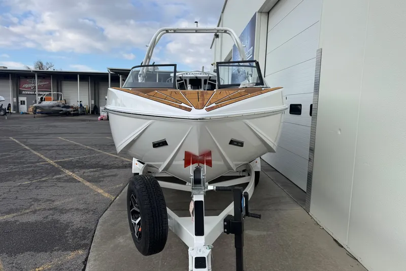 Slide: The Image of 2026 Moomba Mondo boat on trailer, parked outside a service facility. - 5