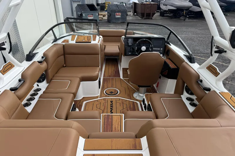 Slide: The Image of 2026 Moomba Mondo boat interior with brown leather seating and modern dashboard. - 8