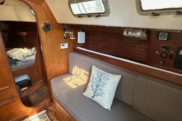 Slide: The Image of 1987 J Boats J28 interior with cozy seating, nautical decor, and wooden accents. - 11