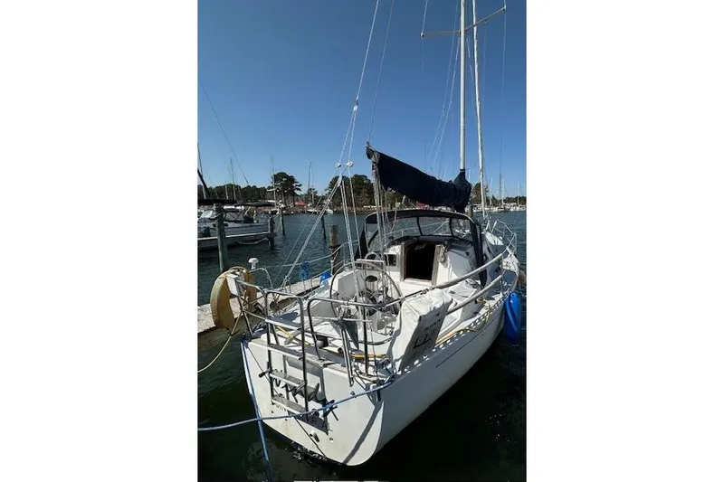 Slide: The Image of 1987 J Boats J28 sailboat docked in a marina under clear blue skies. - 2