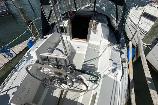 Slide: The Image of 1987 J Boats J28 sailboat cockpit with steering wheel, docked at marina. - 4