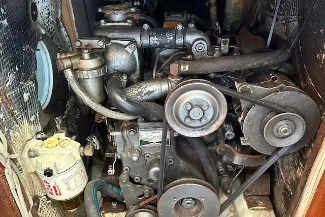 Slide: The Image of Engine compartment of a 1987 J Boats J28 sailboat, showcasing mechanical components and belts. - 6