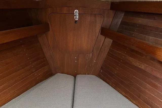 Slide: The Image of 1987 J Boats J28 interior cabin with wooden paneling and cushioned seating. - 8