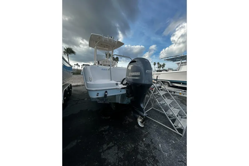 Slide: The Image of 2016 Robalo R222 Center Console boat with Yamaha engine, parked outdoors under cloudy sky. - 11