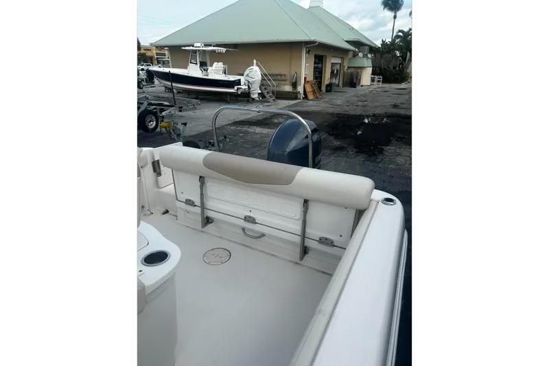 Slide: The Image of 2016 Robalo R222 Center Console boat interior with seating and motor, docked near a building. - 9