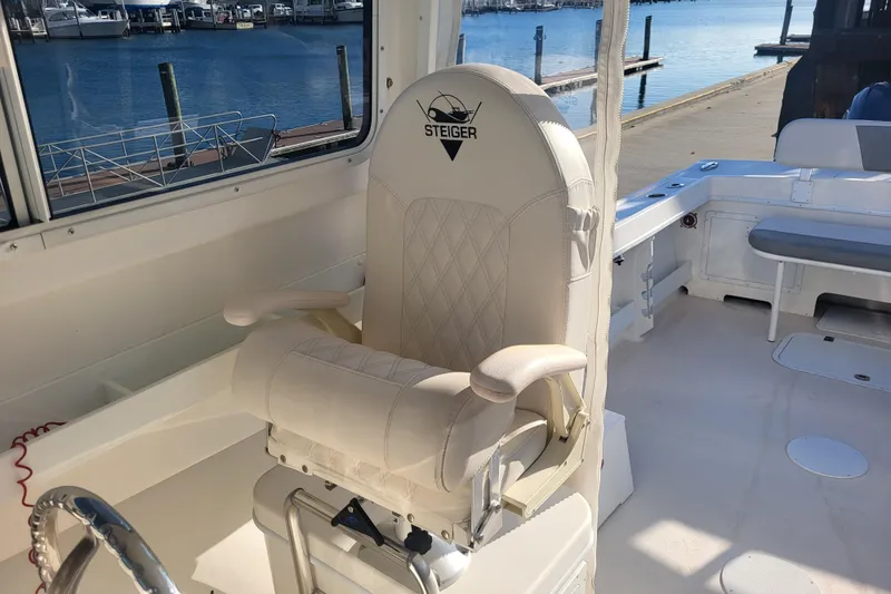 Slide: The Image of Steiger Craft 255 DV MIAMI 2021 boat interior with captain's chair and marina view. - 12
