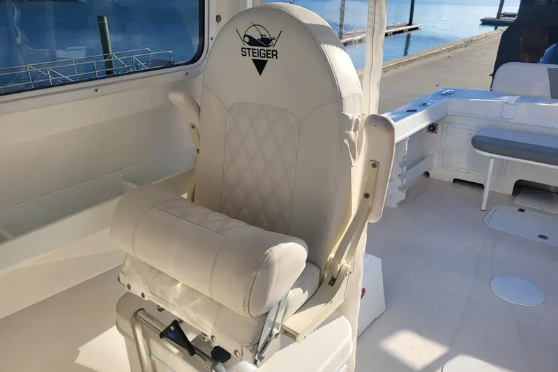 Slide: The Image of Captain's chair on 2021 Steiger Craft 255 DV MIAMI boat, featuring luxurious white upholstery. - 13