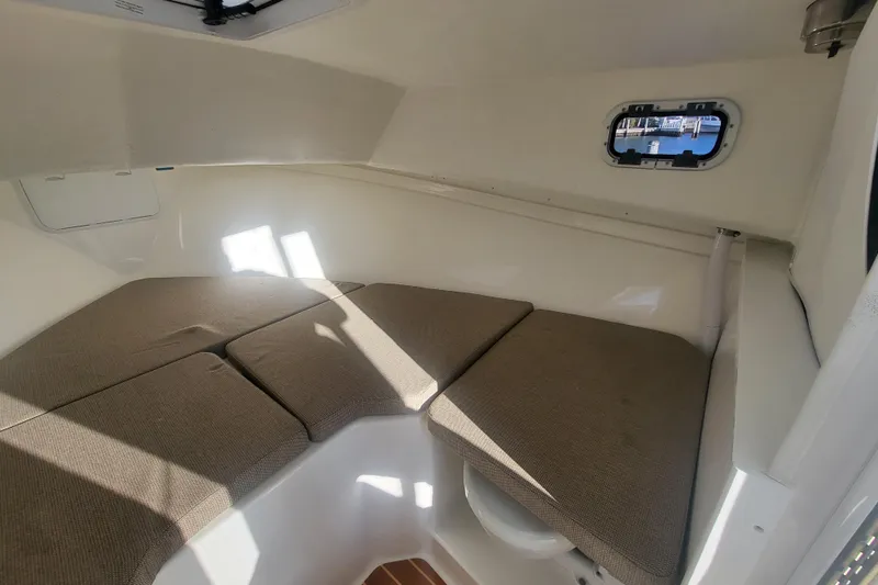 Slide: The Image of 2021 Steiger Craft 255 DV MIAMI cabin interior with cushioned seating and porthole window. - 19