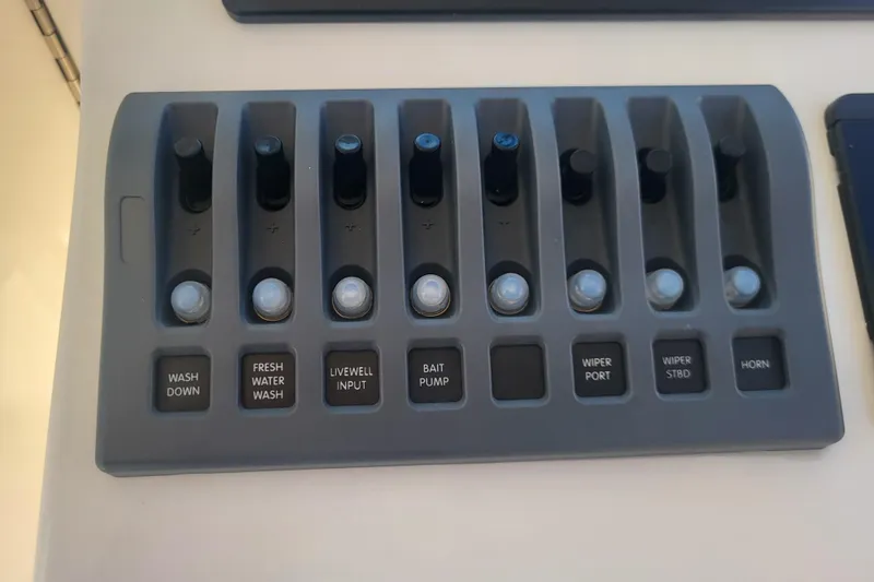 Slide: The Image of Control panel of a 2021 Steiger Craft 255 DV MIAMI boat with labeled switches. - 42
