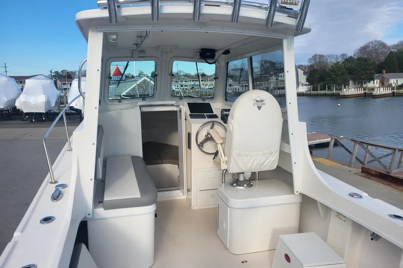 Slide: The Image of 2021 Steiger Craft 255 DV MIAMI boat interior with helm and seating, docked by the water. - 55