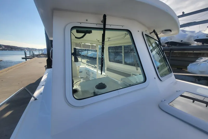 Slide: The Image of 2021 Steiger Craft 255 DV MIAMI boat docked, showcasing cabin windows and sleek design. - 63