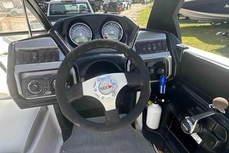 Slide: The Image of Steering wheel and dashboard of a 2012 Axis A20 boat, featuring gauges and controls. - 6